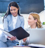 business-woman-showing-paper-documents-her-older-female-colleague-office