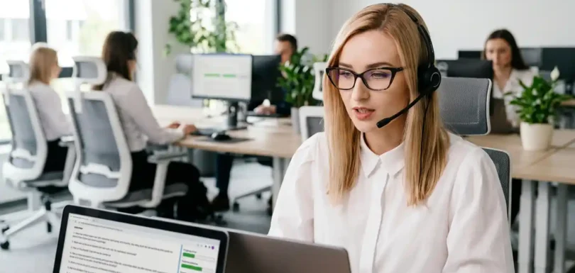 Ankieterka prowadzi badanie metodą CATI w studiu telefonicznym, korzystając z laptopa ze skryptem ankiety