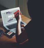 kobieta z kartą płatniczą przed sklepem z obuwiem, telefon z napisem SALE