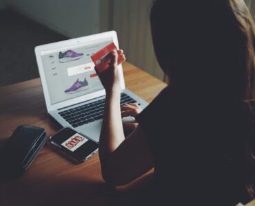 kobieta z kartą płatniczą przed sklepem z obuwiem, telefon z napisem SALE