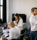 Zespół badawczy planuje projekt przy ścianie z karteczkami i laptopach z danymi - badanie rynku niszowego B2B